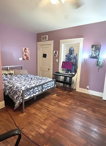 a bedroom with a bed and wooden floor