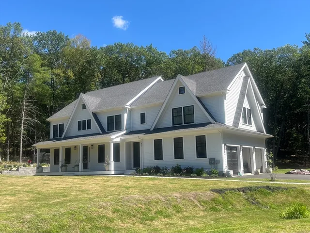a aerial view of a house next to a big yard with plants and large trees