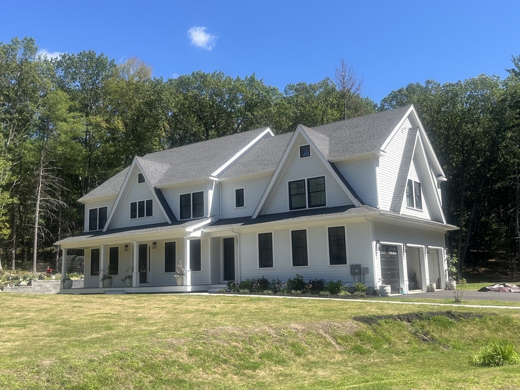a aerial view of a house next to a big yard with plants and large trees