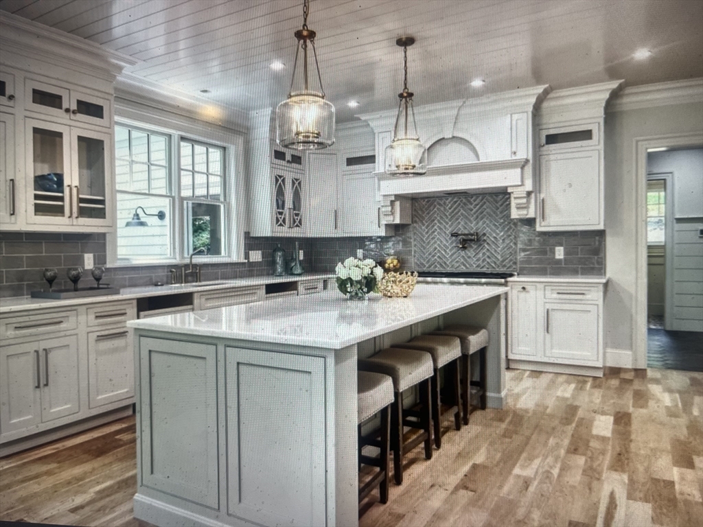 45 Widow Rites Lane Sudbury, MA 01776 - Photo 15 of 25 a kitchen with kitchen island granite countertop a sink a counter space appliances and cabinets