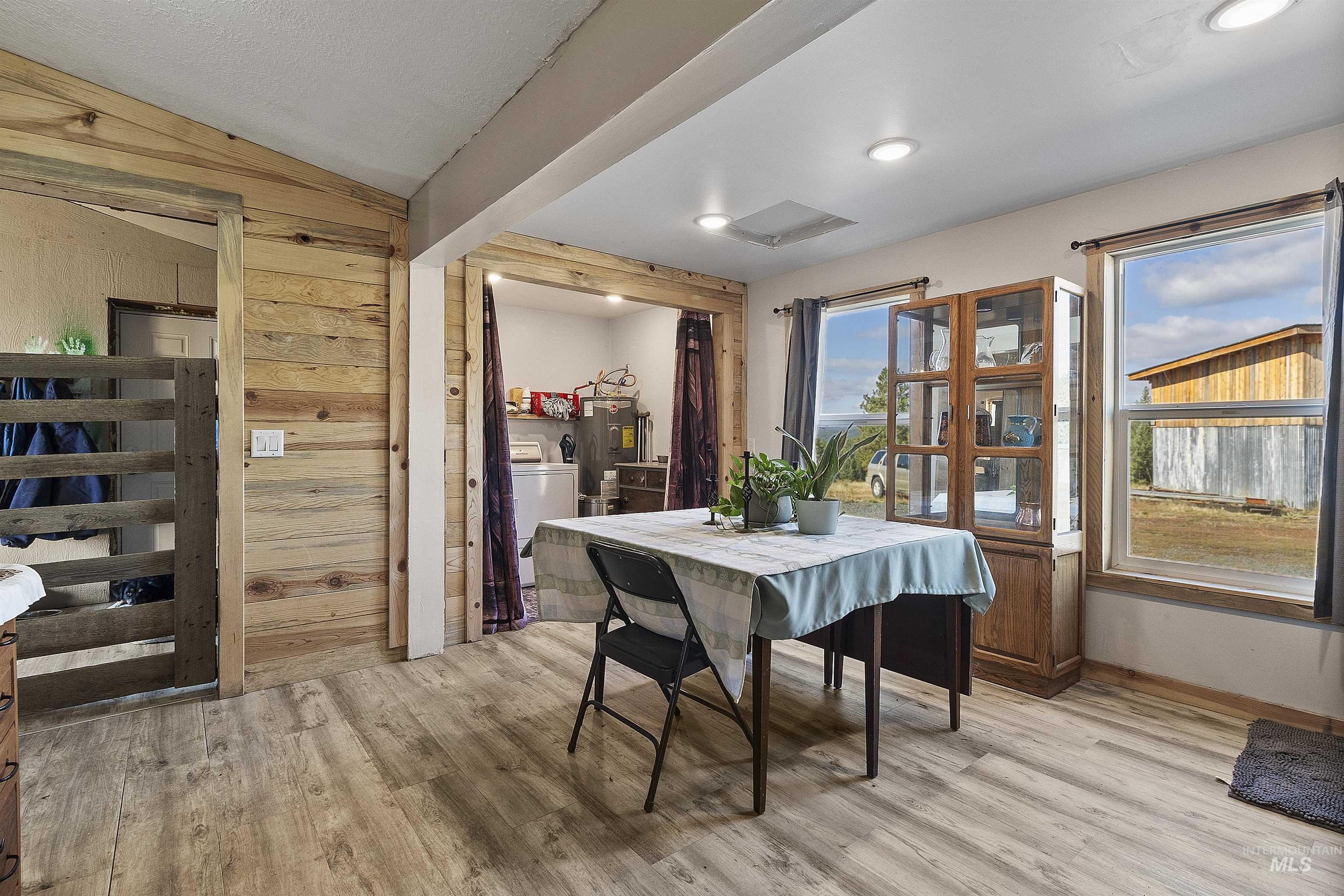 1311 Gold Hill Road Princeton, ID 83857 - Photo 14 of 25 Dining area with wood walls, light wood-type flooring, washer / clothes dryer, and water heater