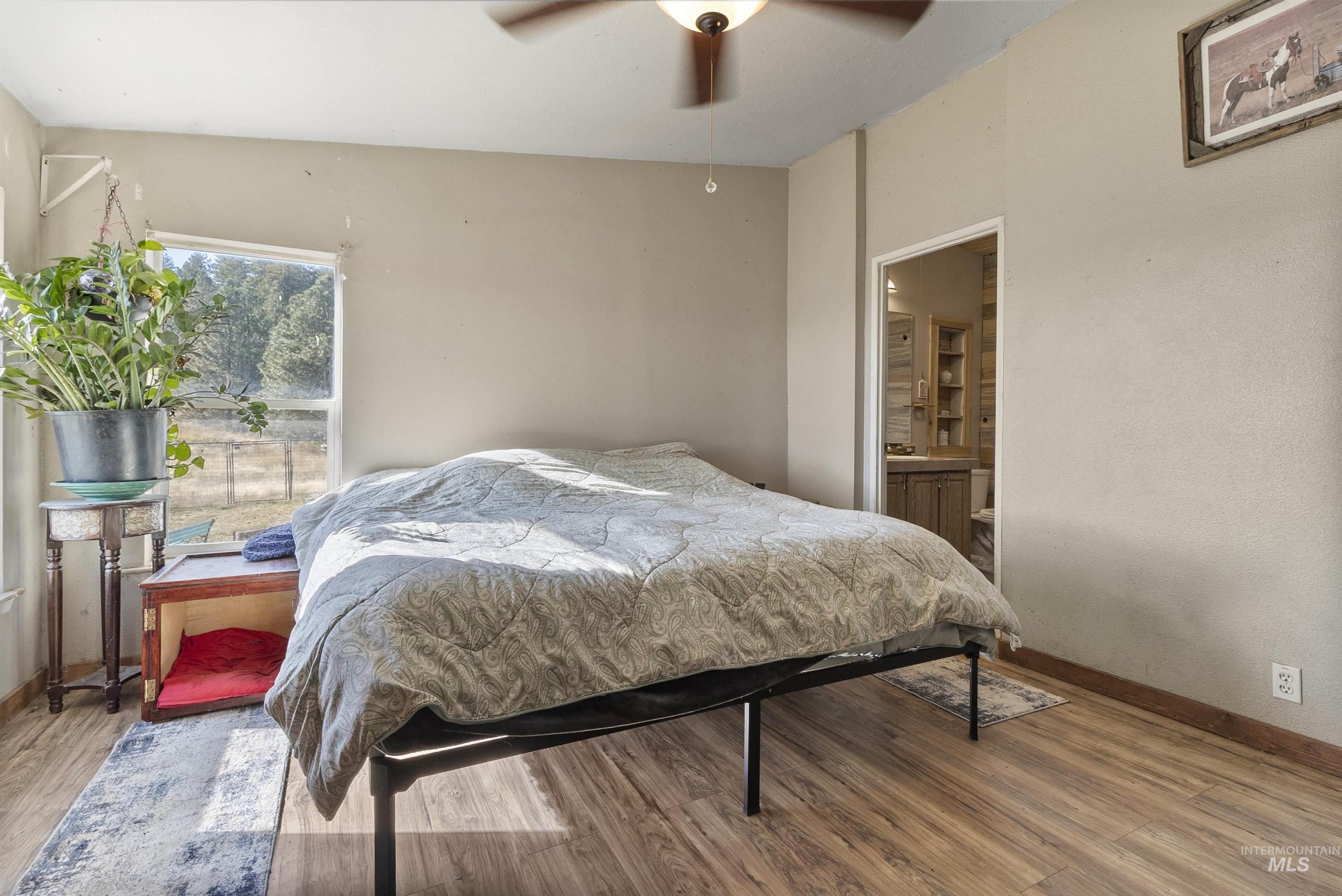 1311 Gold Hill Road Princeton, ID 83857 - Photo 16 of 25 Bedroom with wood finished floors, ensuite bathroom, and a ceiling fan