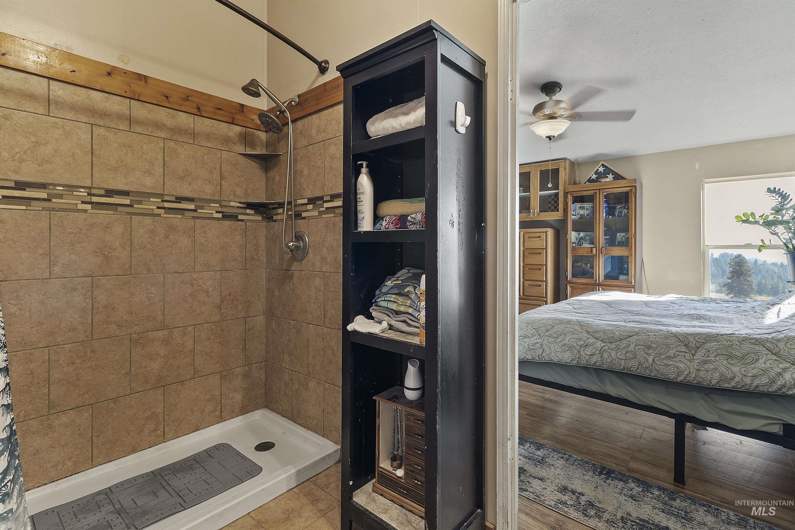 1311 Gold Hill Road Princeton, ID 83857 - Photo 18 of 25 Full bath with connected bathroom, a stall shower, tile patterned flooring, and a ceiling fan
