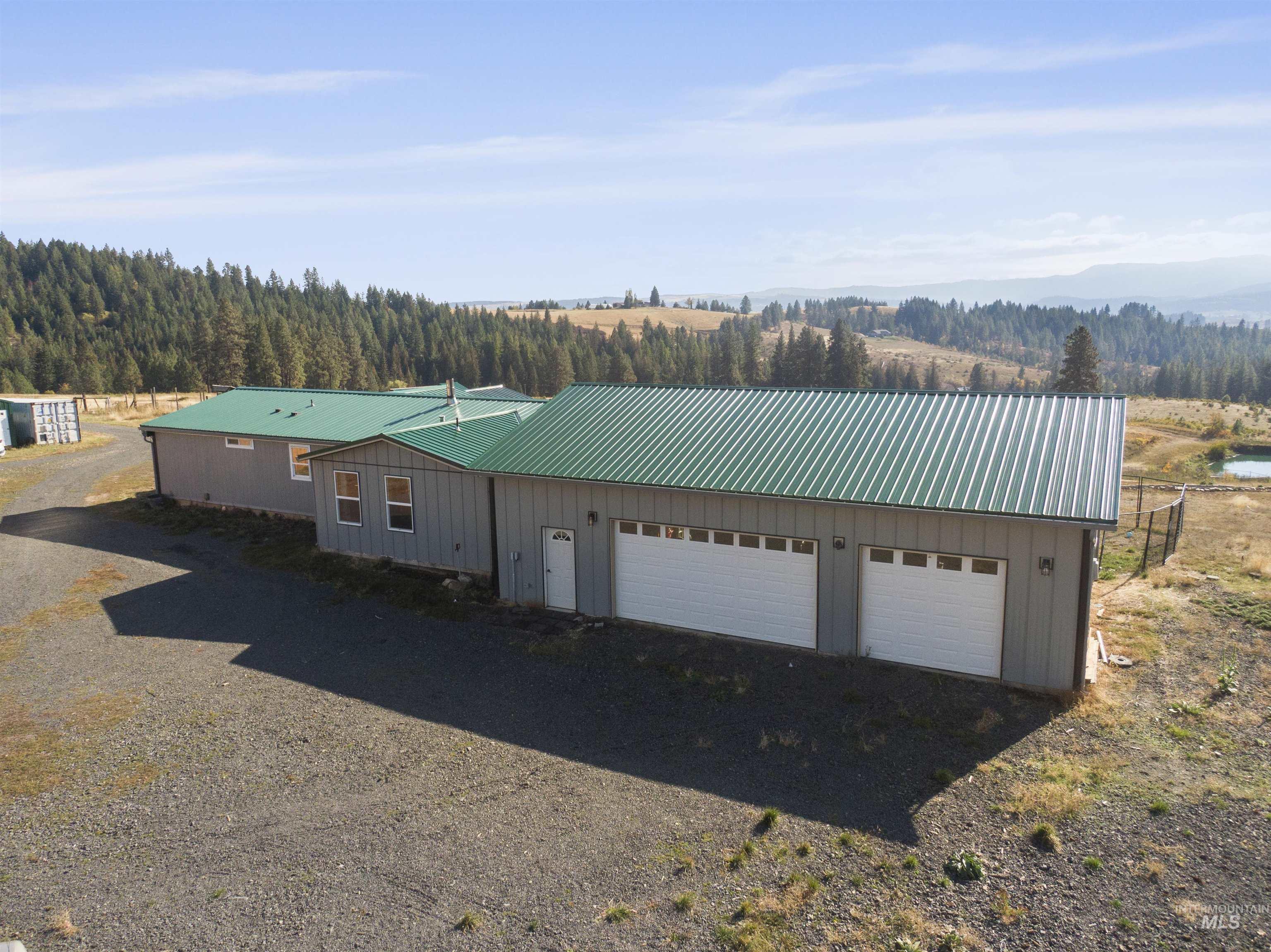 1311 Gold Hill Road Princeton, ID 83857 - Photo 23 of 25 View of front of home with a metal roof, driveway, a garage, and board and batten siding