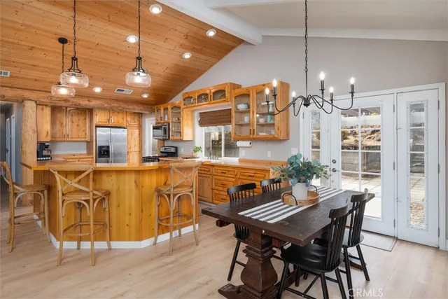 a dining room with stainless steel appliances kitchen island granite countertop a table chairs and a living room view
