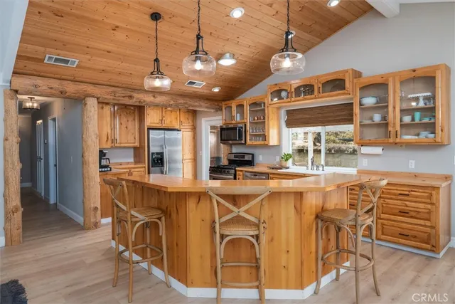 a view of a kitchen with kitchen island dining table and stainless steel appliances
