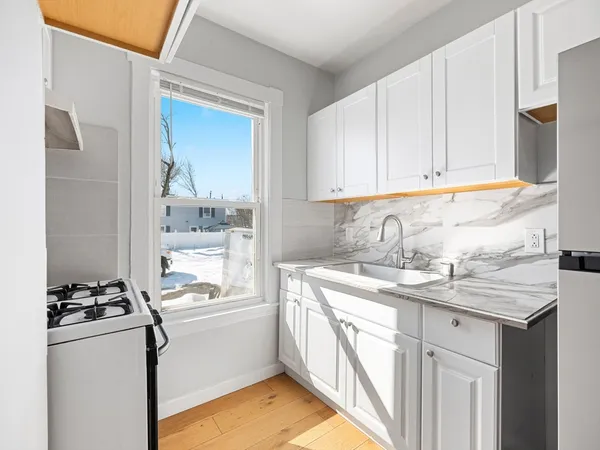 a view of a room with wooden floor and mirror