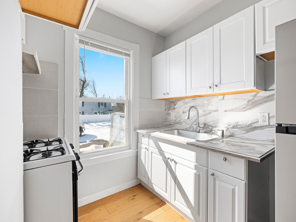 37 Howard Street Lynn, MA 01902 - Photo 11 of 42 a kitchen with a sink stove and refrigerator