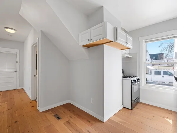 a view of a room with wooden floor and white walls