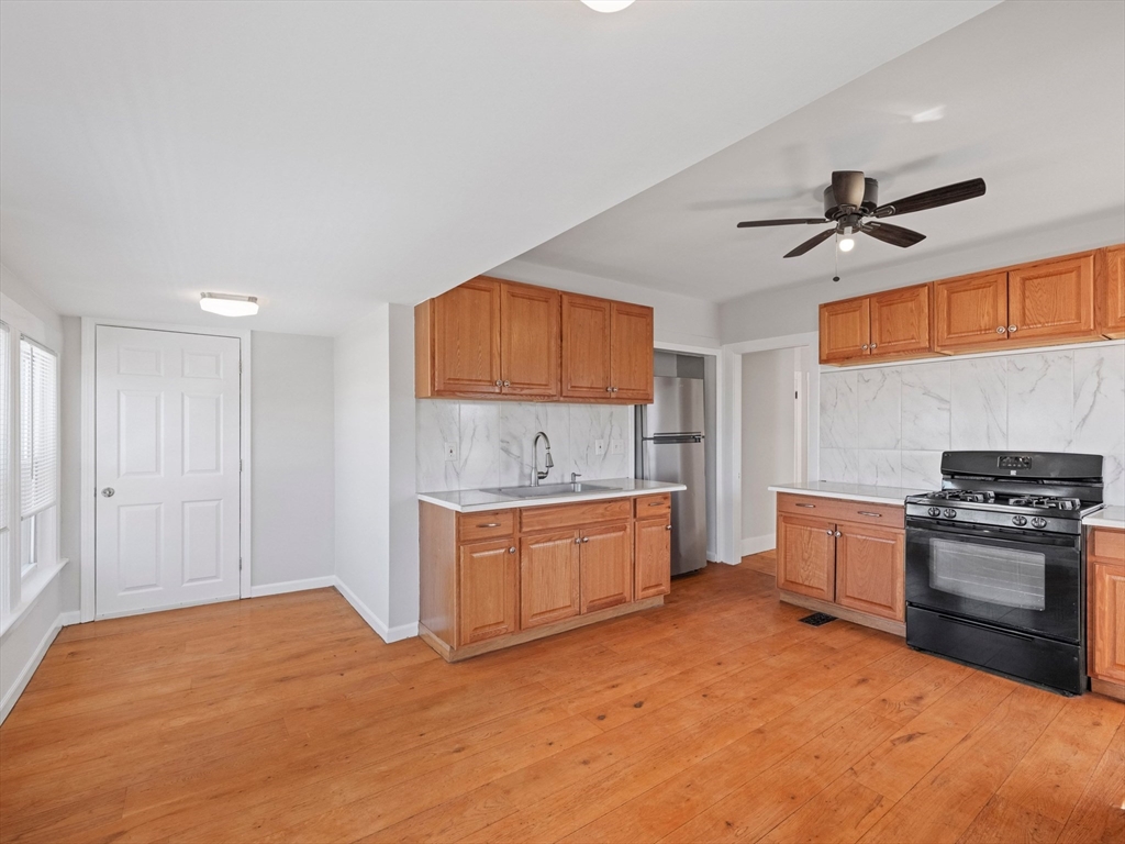 37 Howard Street Lynn, MA 01902 - Photo 27 of 42 a kitchen with stainless steel appliances granite countertop a stove a sink and a refrigerator