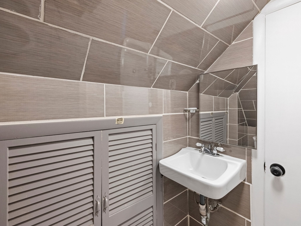 37 Howard Street Lynn, MA 01902 - Photo 40 of 42 a bathroom with a sink a toilet and a mirror