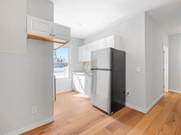 a view of a kitchen with a sink and refrigerator