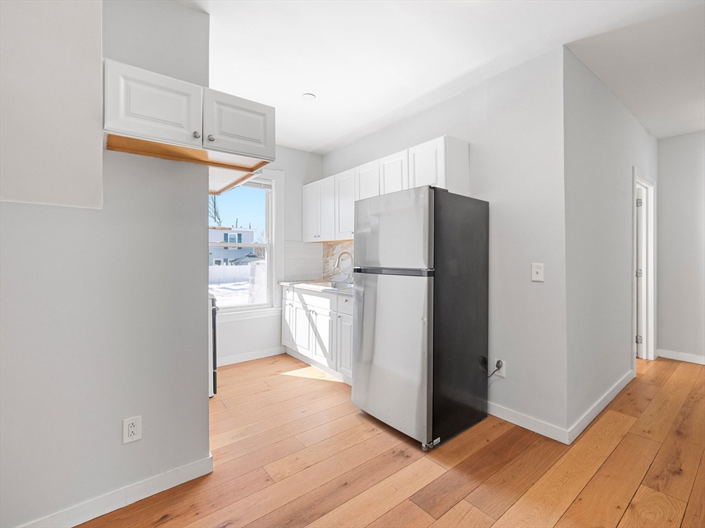 37 Howard Street Lynn, MA 01902 - Photo 10 of 42 a kitchen with refrigerator cabinets and wooden floor