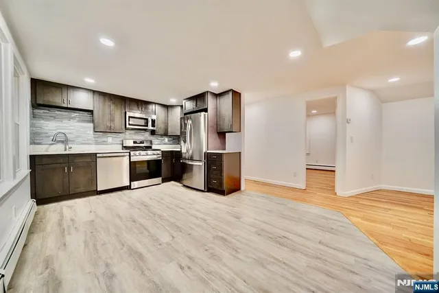 a large kitchen with stainless steel appliances granite countertop a stove and a refrigerator