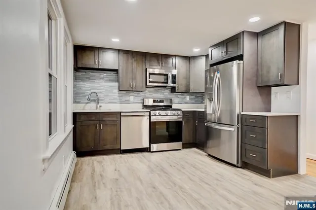 a kitchen with stainless steel appliances kitchen island granite countertop a refrigerator stove and oven