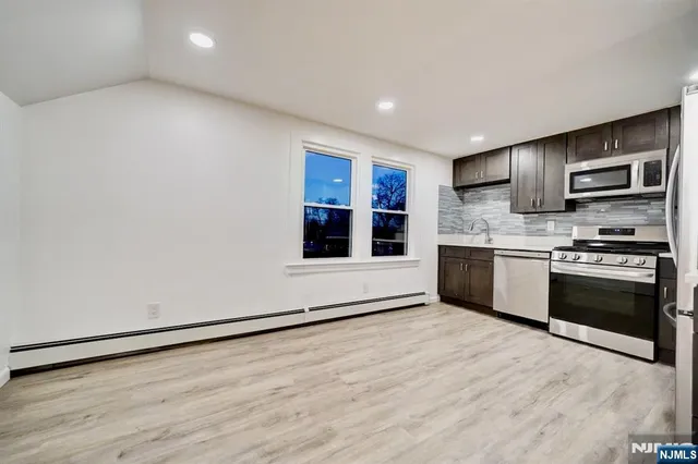 a kitchen with stainless steel appliances a stove top oven a sink and a microwave