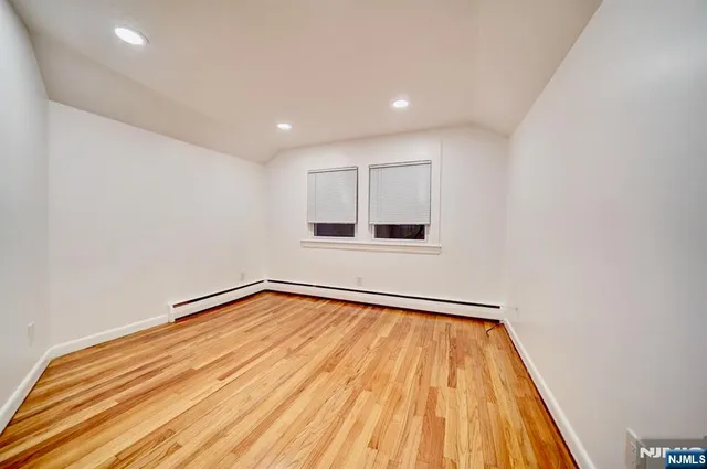 a view of a room with wooden floor and white walls