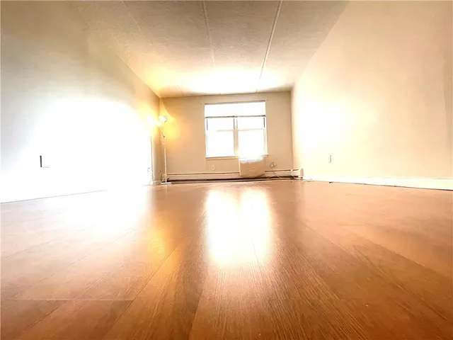 an empty room with a ceiling fan and a window