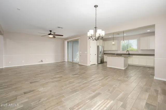 a view of a kitchen with a sink dishwasher a refrigerator and chandelier