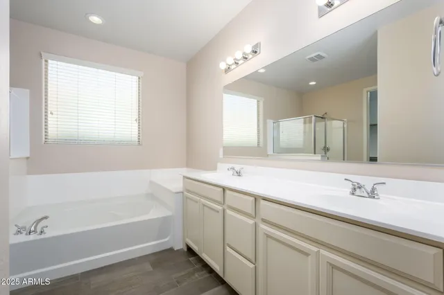 a bathroom with a tub a sink and mirror
