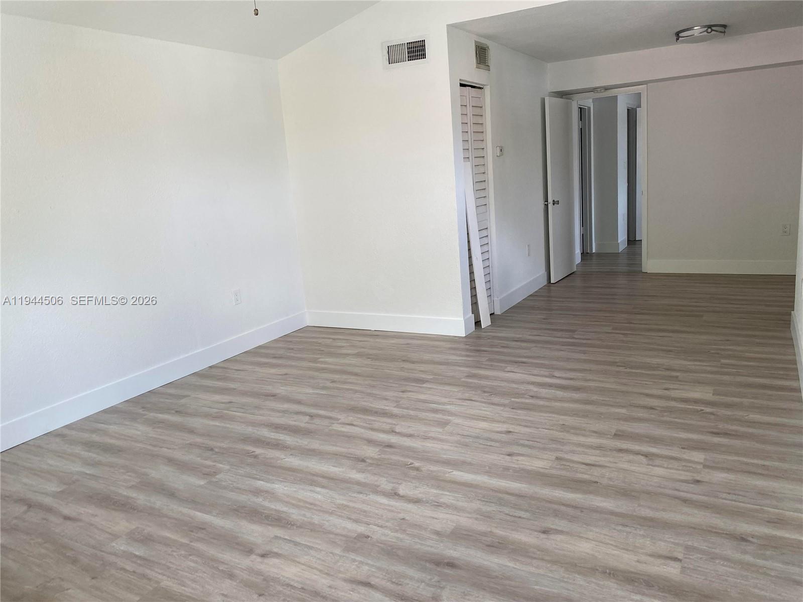 10441 Southwest 155th Court, Unit 921 Miami, FL 33196 - Photo 2 of 46 a view of an empty room with wooden floor
