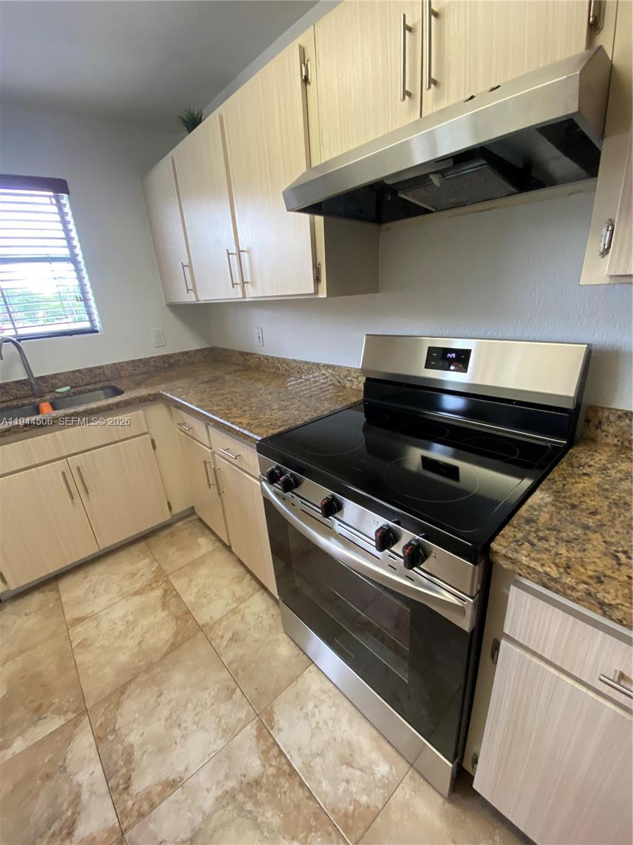 10441 Southwest 155th Court, Unit 921 Miami, FL 33196 - Photo 26 of 46 a kitchen with granite countertop a stove and a sink