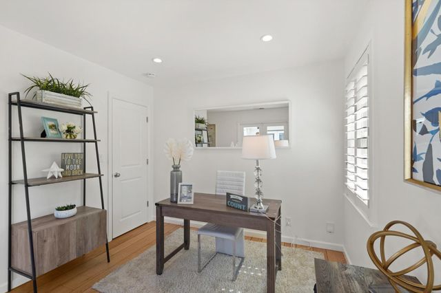 a view of a workspace room with furniture and window