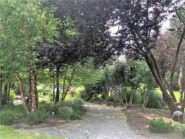 a view of a street with a yard and a wooden fence