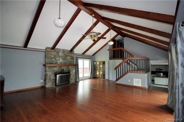 a view of an entryway with wooden floor a fireplace and a window