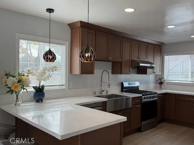 a kitchen with granite countertop a sink a stove and cabinets
