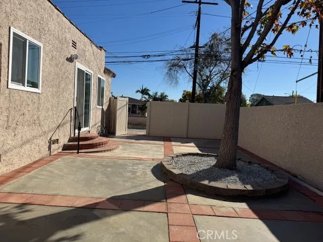 a view of a patio with table and chairs with wooden fence and plants