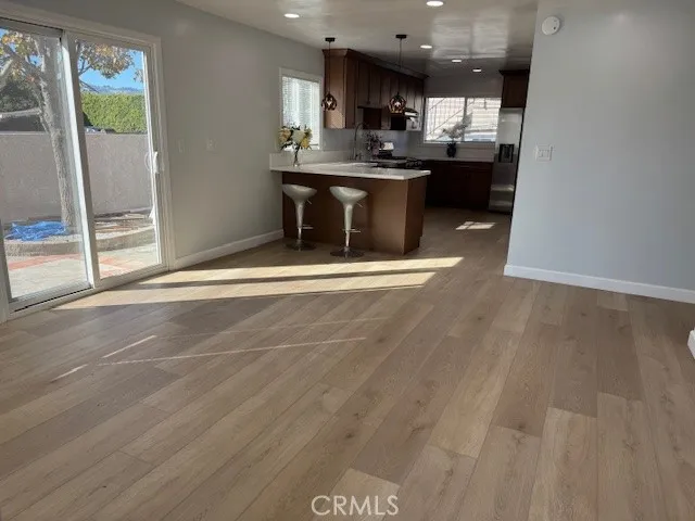 a living room with stainless steel appliances kitchen island granite countertop a refrigerator a sink a stove and a oven