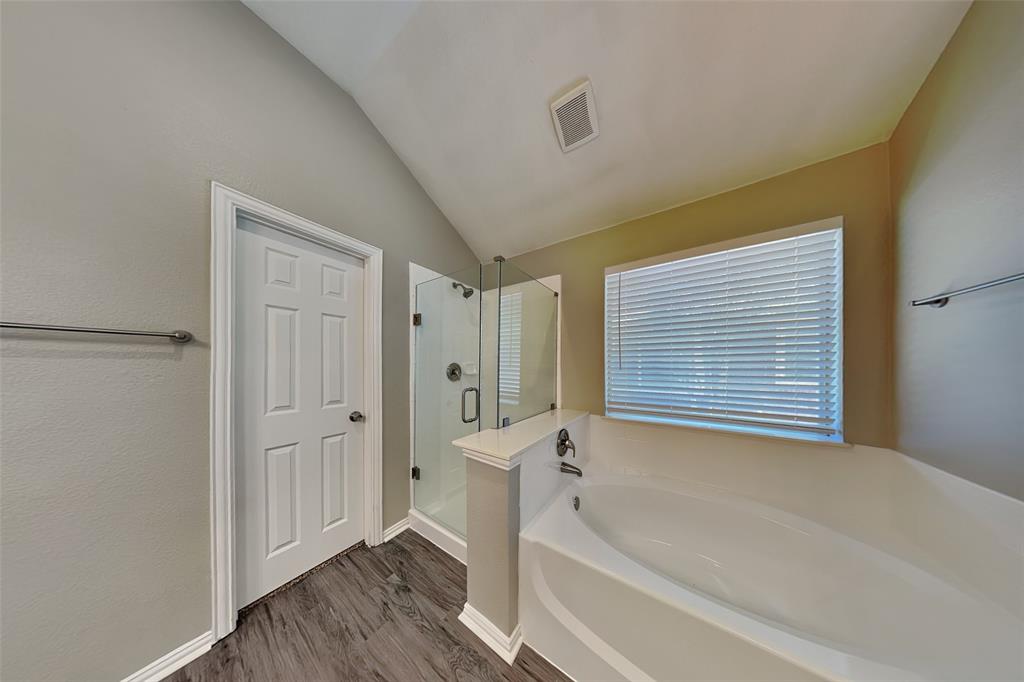 1703 Travis Court Allen, TX 75002 - Photo 12 of 21 Full bathroom featuring a stall shower, a bath, vaulted ceiling, and dark wood finished floors