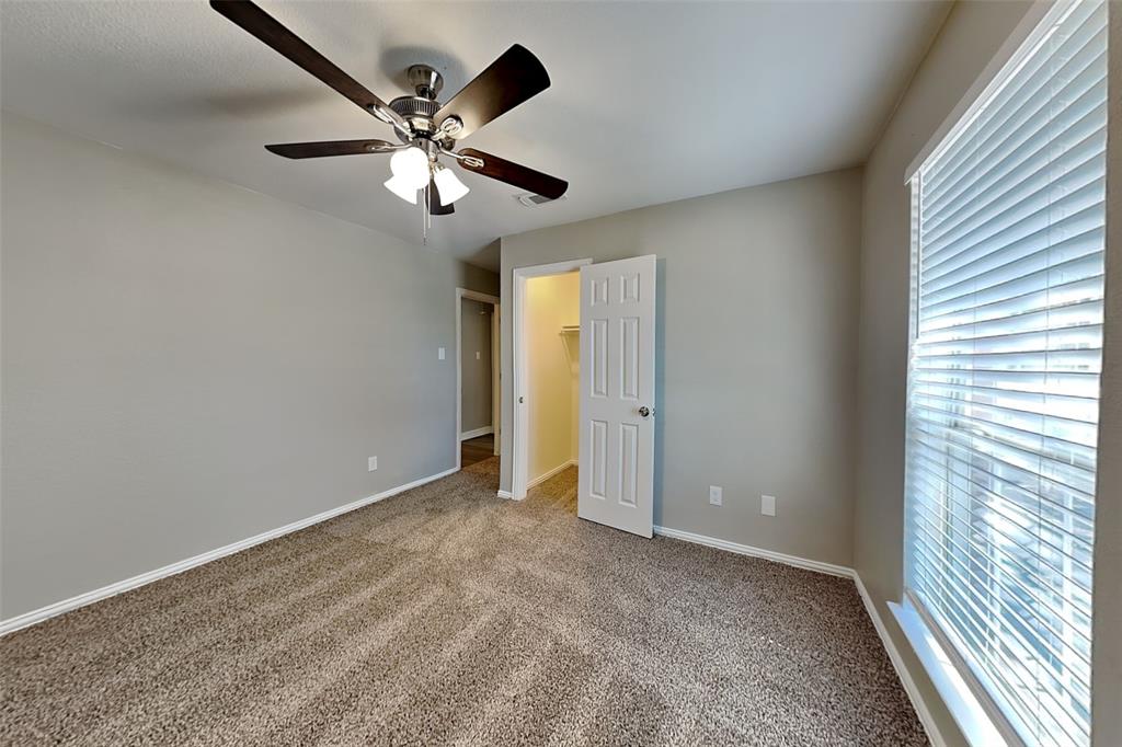 1703 Travis Court Allen, TX 75002 - Photo 15 of 21 Unfurnished bedroom with a walk in closet, carpet, and ceiling fan