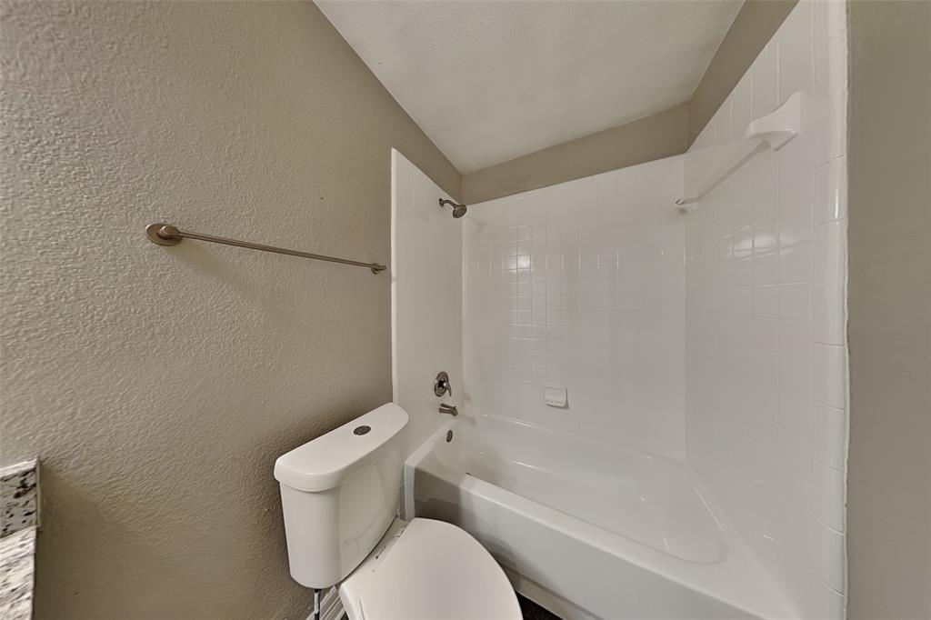 1703 Travis Court Allen, TX 75002 - Photo 18 of 21 Bathroom featuring a textured wall and bathtub / shower combination