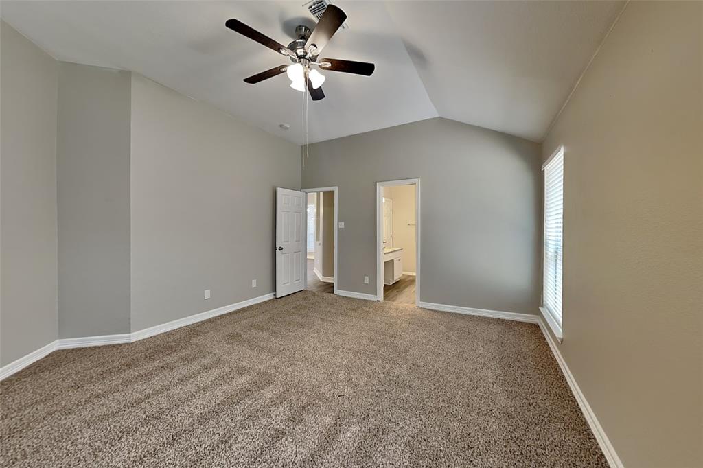 1703 Travis Court Allen, TX 75002 - Photo 9 of 21 Unfurnished bedroom featuring vaulted ceiling, carpet, ceiling fan, and ensuite bath