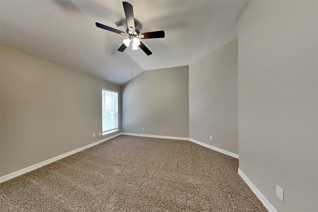 1703 Travis Court Allen, TX 75002 - Photo 10 of 21 Spare room with vaulted ceiling, light carpet, and ceiling fan