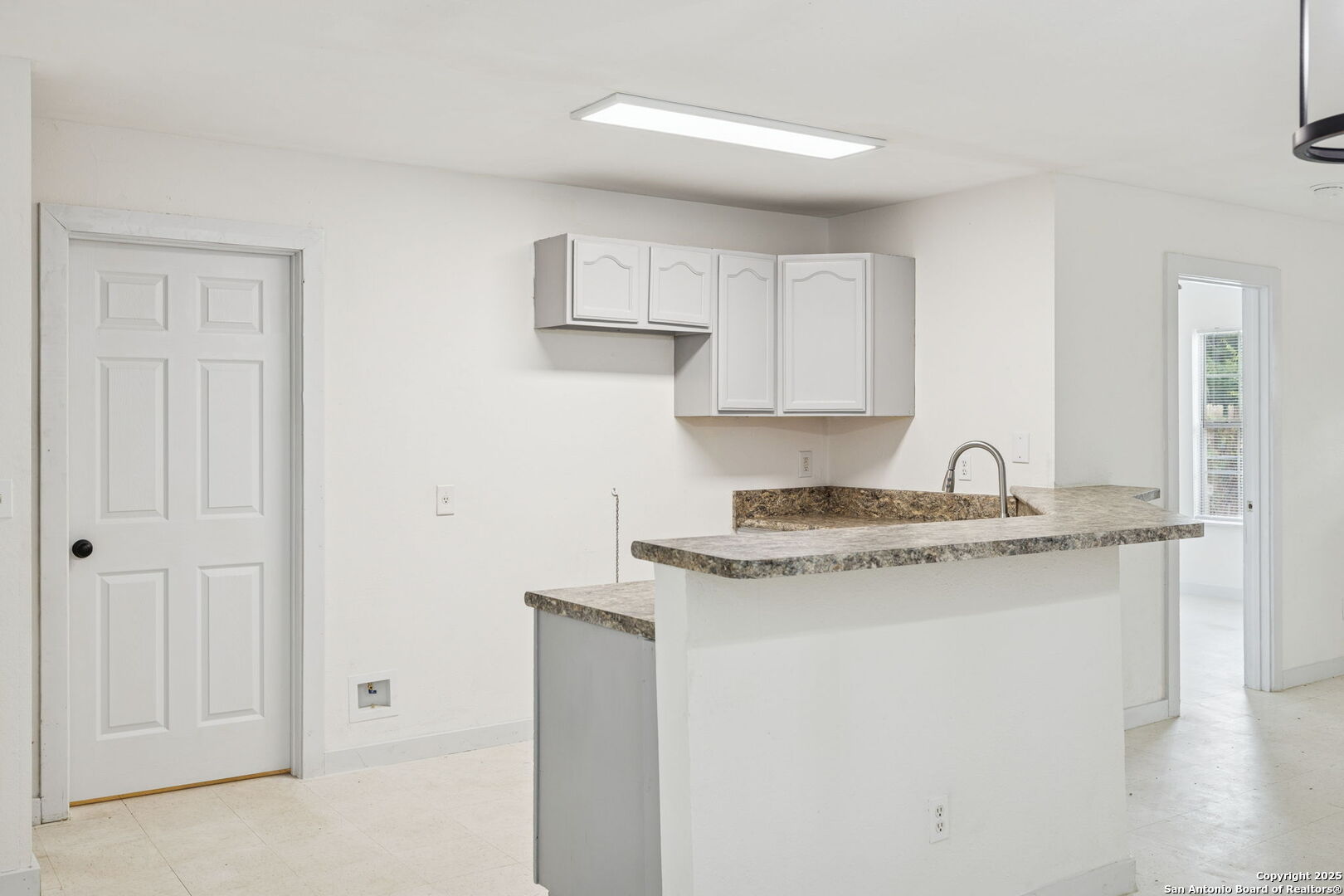 1349 Rivas Street San Antonio, TX 78207 - Photo 16 of 35 a kitchen with granite countertop white cabinets and a sink