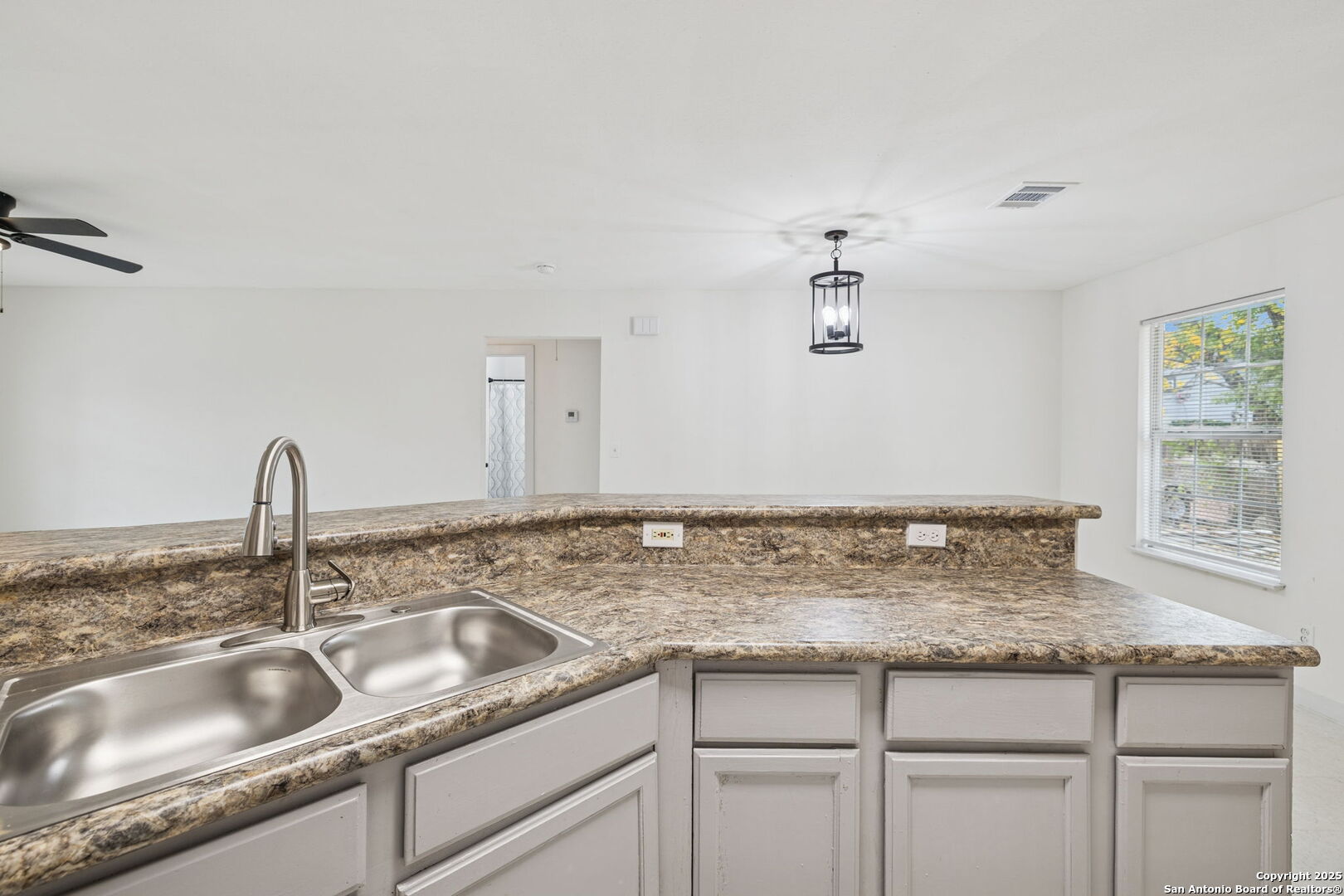 1349 Rivas Street San Antonio, TX 78207 - Photo 19 of 35 a kitchen with granite countertop a sink and cabinets
