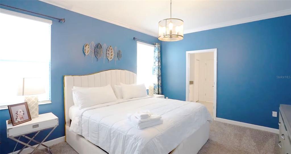 2940 Simile Street Kissimmee, FL 34746 - Photo 11 of 51 a bedroom with a bed and a chandelier