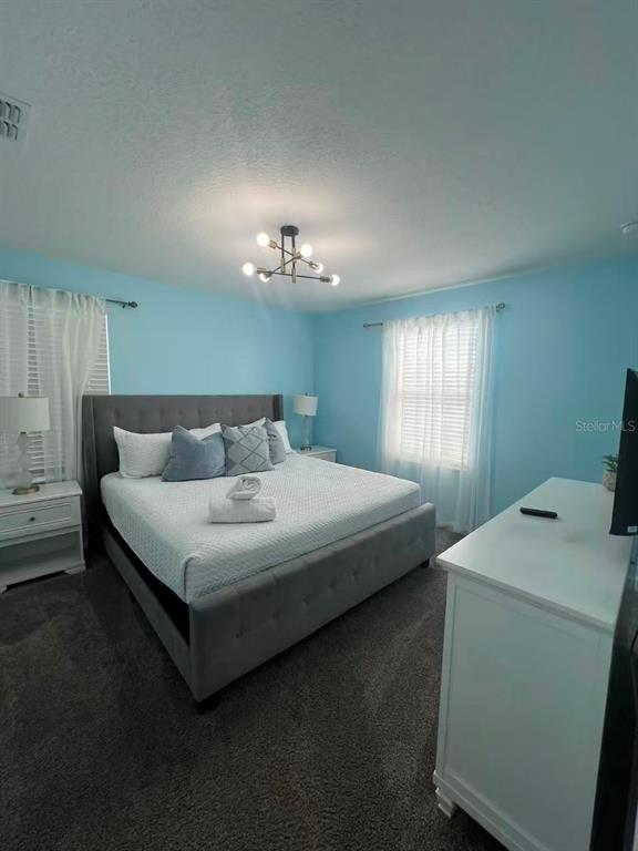 2940 Simile Street Kissimmee, FL 34746 - Photo 39 of 51 a bedroom with a bed and a chandelier