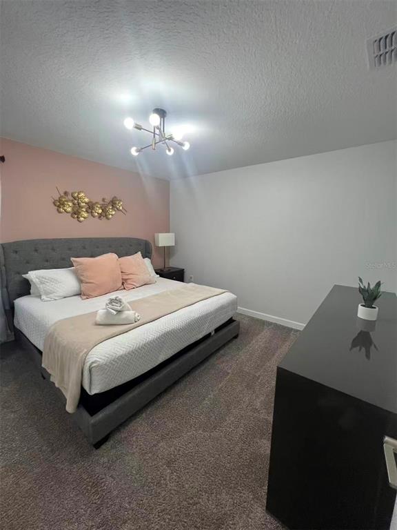 2940 Simile Street Kissimmee, FL 34746 - Photo 44 of 51 a bedroom with a bed and a chandelier