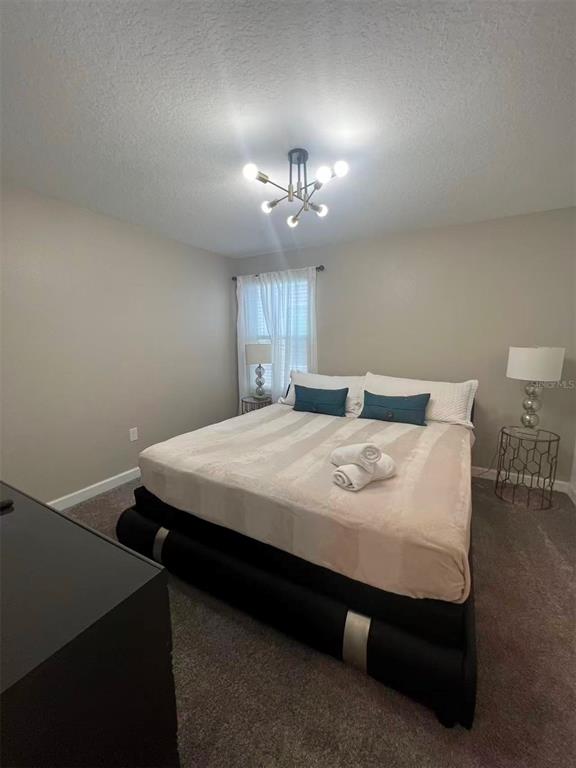 2940 Simile Street Kissimmee, FL 34746 - Photo 48 of 51 a spacious bedroom with a bed and a chandelier