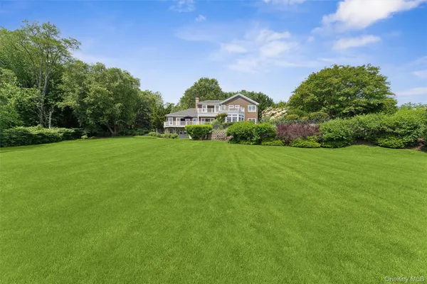 a front view of a house with a yard and trees