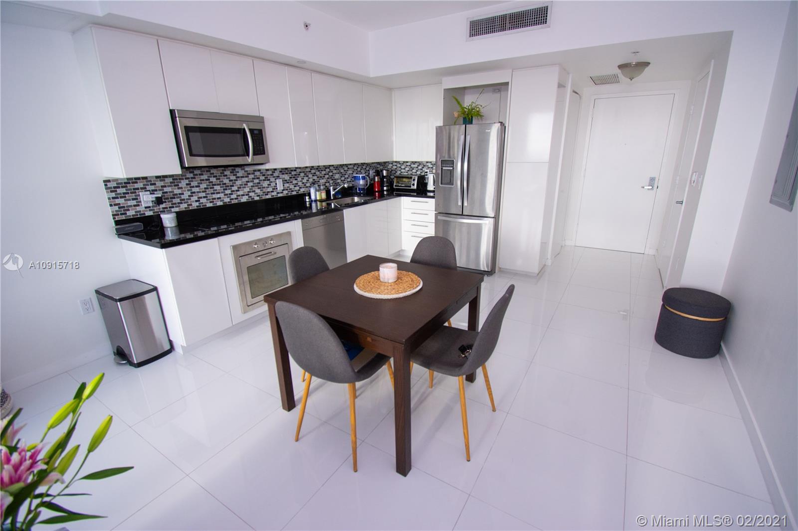 92 Southwest 3rd Street, Unit 2307 Miami, FL 33130 - Photo 2 of 18 a view of a dining room with furniture and a wooden floor