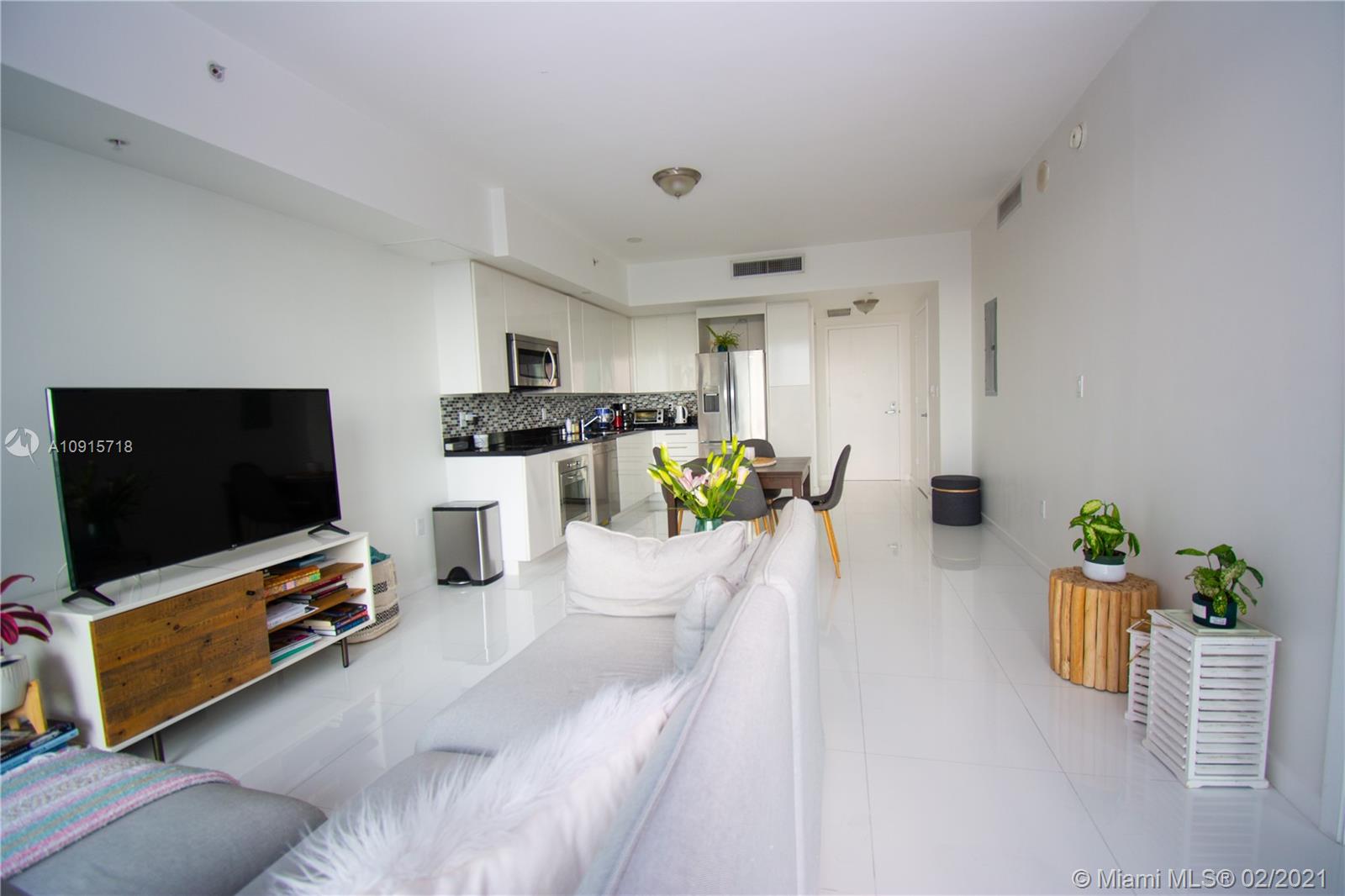 92 Southwest 3rd Street, Unit 2307 Miami, FL 33130 - Photo 4 of 18 a living room with furniture and a flat screen tv