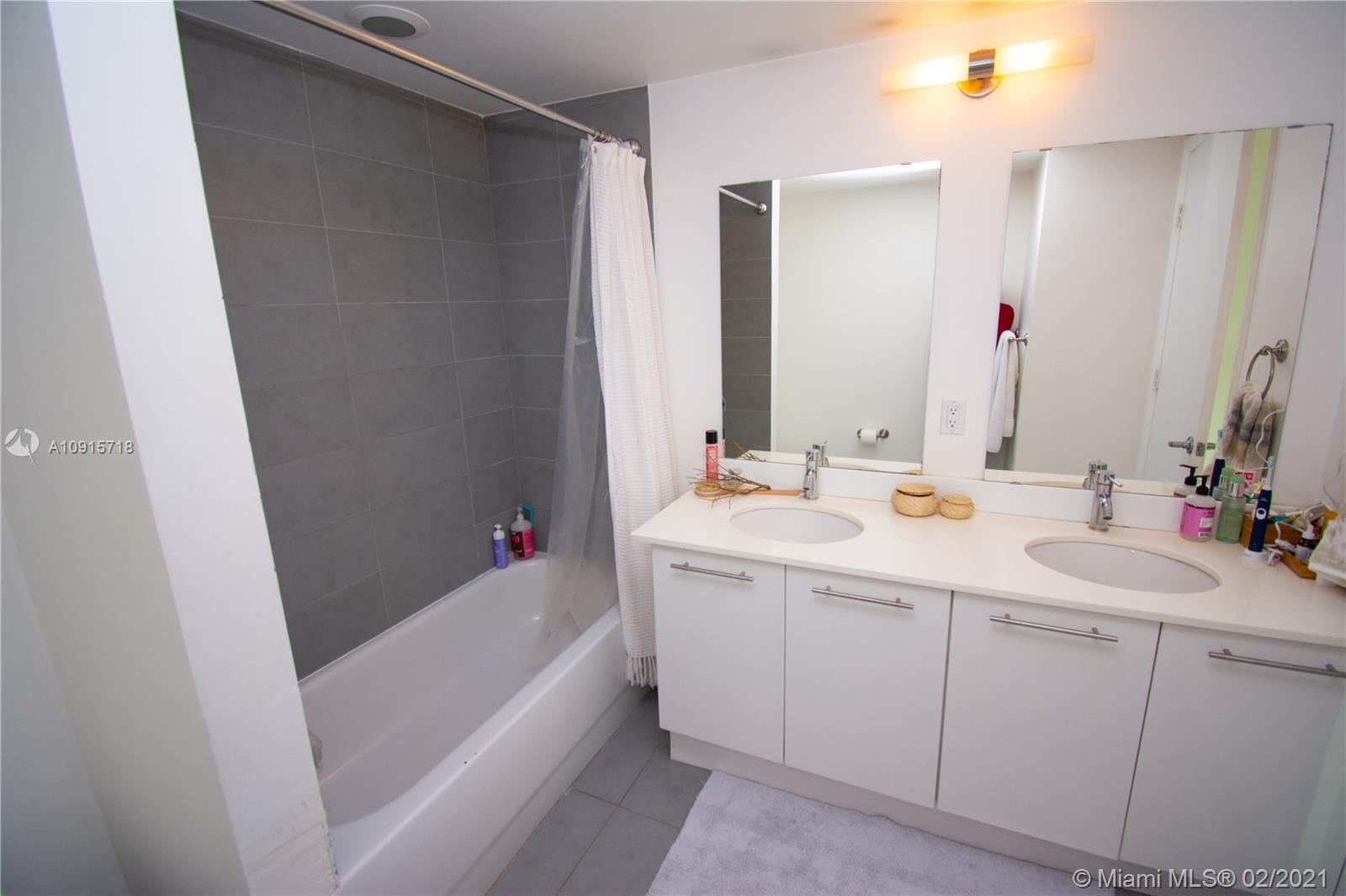 92 Southwest 3rd Street, Unit 2307 Miami, FL 33130 - Photo 10 of 18 a bathroom with a sink and a mirror
