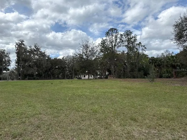 a view of a field and trees