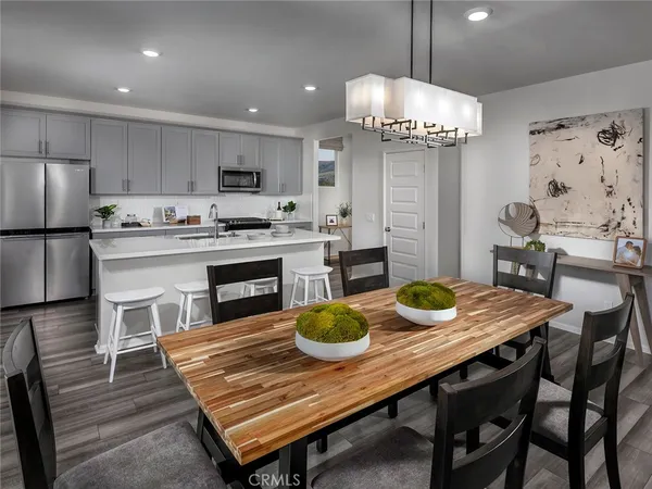 a kitchen with a table chairs and refrigerator