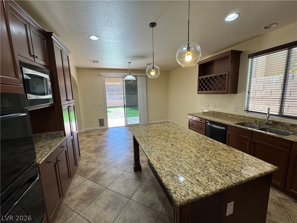 1333 Jamesbury Road Las Vegas, NV 89135 - Photo 19 of 43 Culinary aspirations find their home in this well-appointed kitchen, featuring a spacious granite island and rich cabinetry.